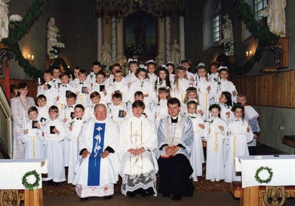  I Komunia Święta w 1995r.  Pani katechetka Wiesława Ptak , kapłani : ks. Benon Hojeński , ks. Krzysztof Tomaszewski i ks. Ireneusz Powaga oraz dzieci pierwszokomunijne . 